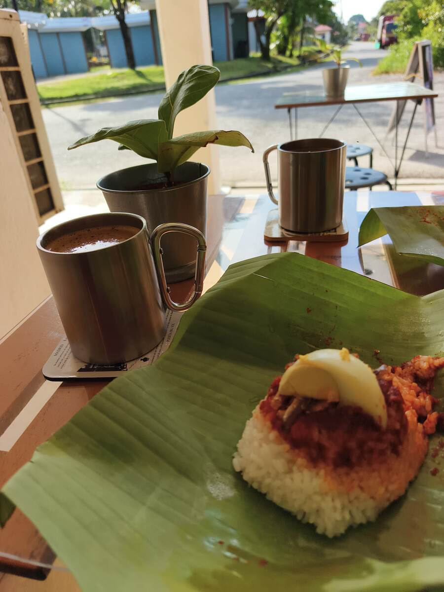 EZU2GO branded coffee cups — hot kopi and iced chocolate — with kuih under a glass dome